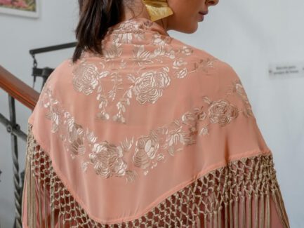mantones de flamenca salmón con flor bordada en dorado y flecos dorados en modelo